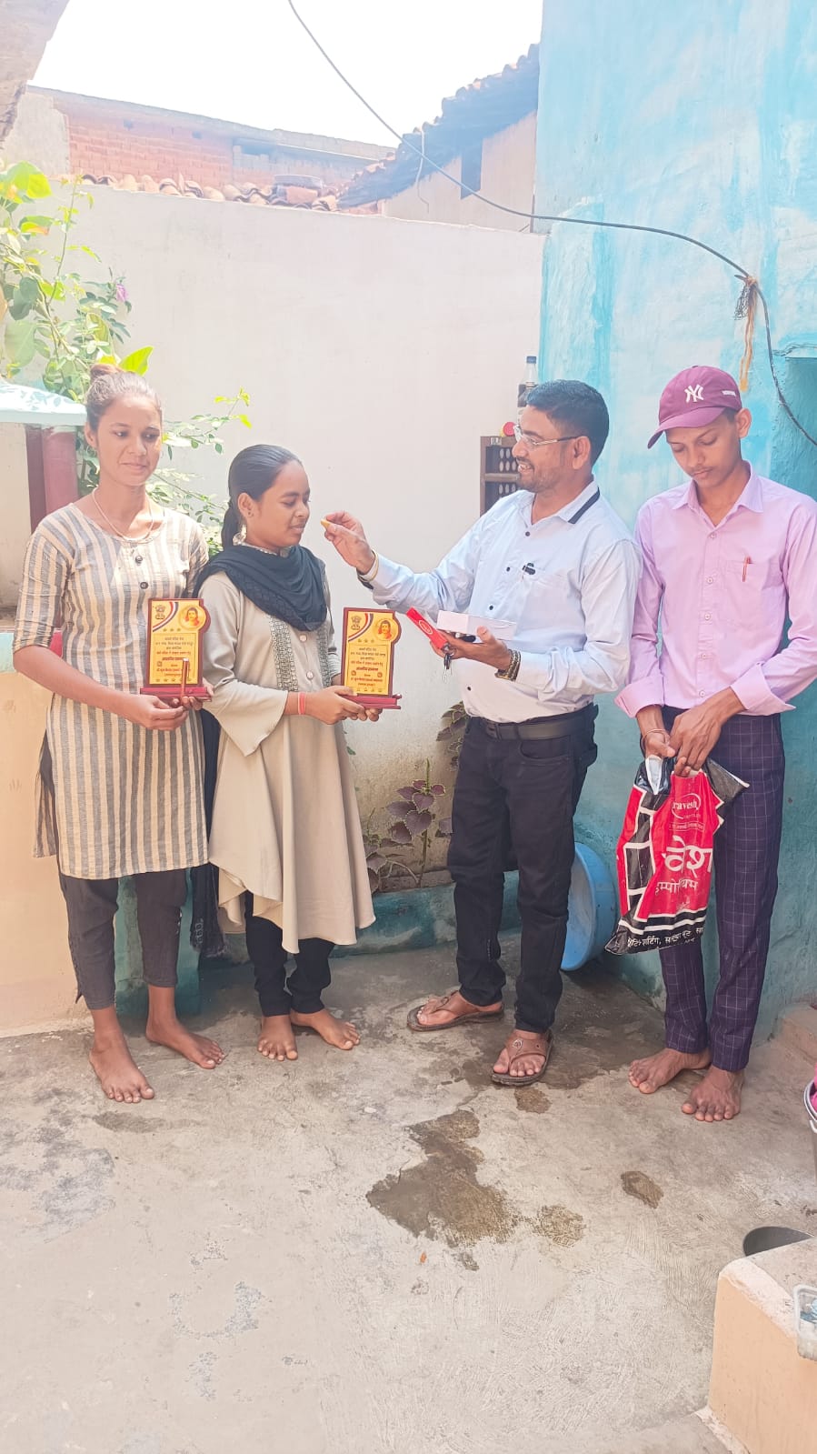 उत्कृष्ट परिणाम में बच्चों को मिठाई खिलाकर मोमेंट देते हुए